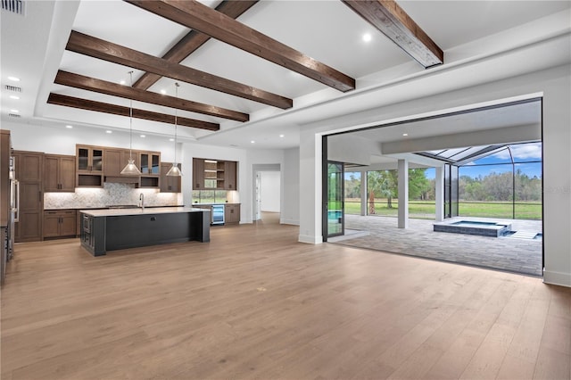 living area with light wood-style flooring, recessed lighting, a sunroom, baseboards, and beam ceiling