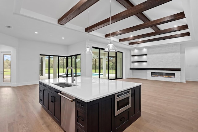 kitchen featuring stainless steel appliances, open floor plan, visible vents, and a sink