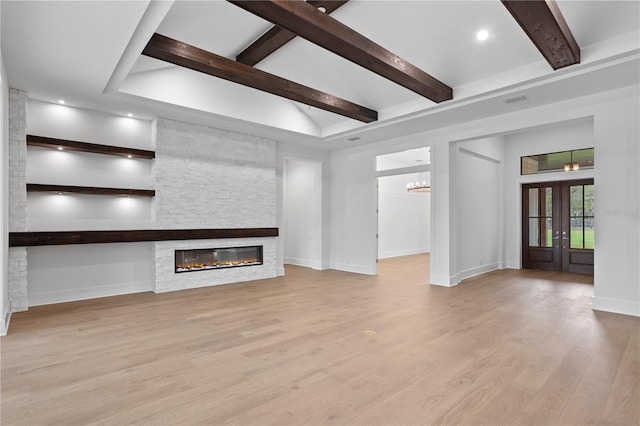 unfurnished living room featuring visible vents, wood finished floors, beamed ceiling, french doors, and a fireplace