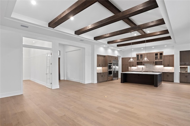 interior space featuring a high ceiling, visible vents, baseboards, light wood-type flooring, and beam ceiling