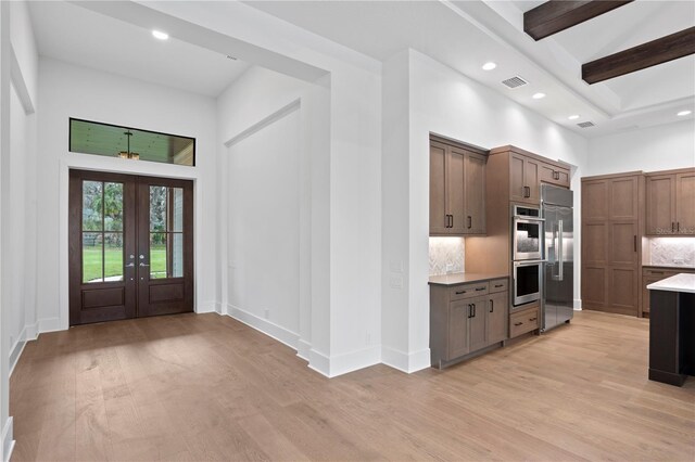 kitchen with stainless steel appliances, tasteful backsplash, visible vents, and light wood-style floors