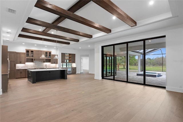 living room featuring beam ceiling, baseboards, visible vents, and light wood finished floors