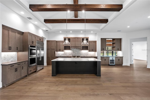 kitchen with beverage cooler, wood finished floors, a sink, appliances with stainless steel finishes, and open shelves