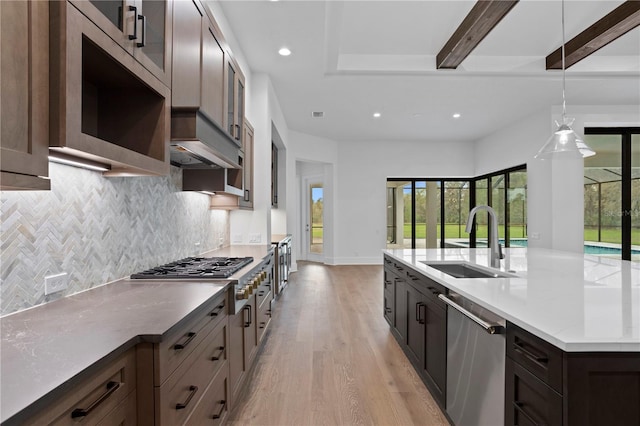 kitchen featuring recessed lighting, decorative backsplash, appliances with stainless steel finishes, light wood-style floors, and a sink