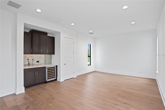 bar with wine cooler, a sink, visible vents, wet bar, and tasteful backsplash