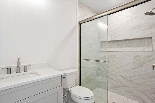 bathroom featuring a stall shower, vanity, and toilet