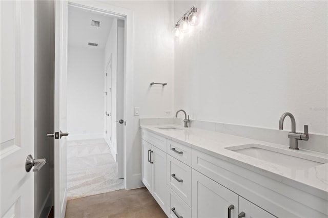 bathroom with double vanity, a sink, and visible vents