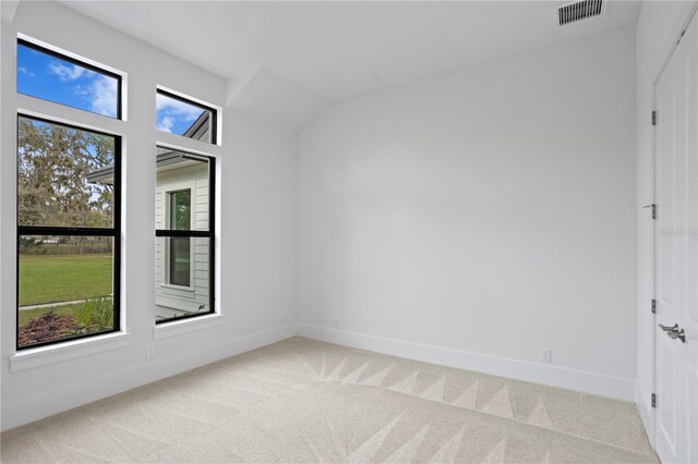 spare room with visible vents, light carpet, and baseboards