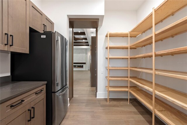 kitchen featuring light wood-type flooring and freestanding refrigerator