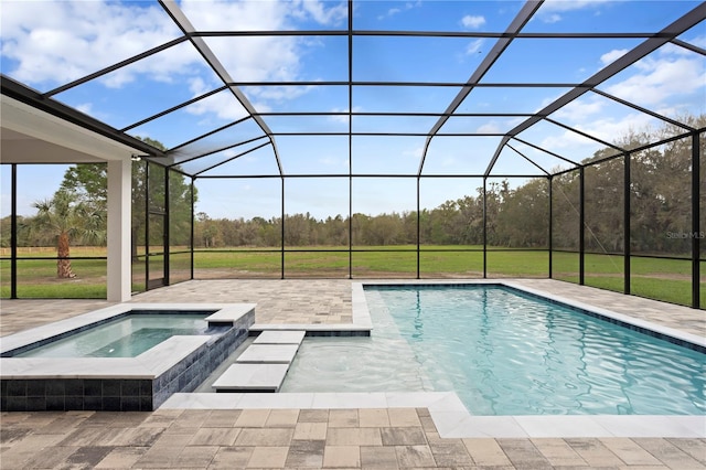 outdoor pool with glass enclosure, an in ground hot tub, and a patio