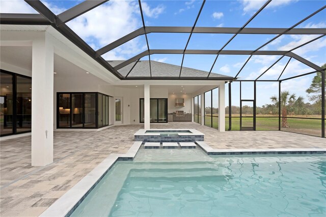 outdoor pool featuring a lanai, a patio area, and an outdoor kitchen