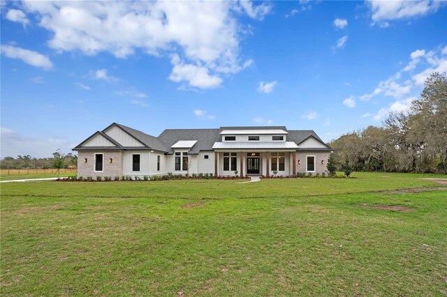 modern farmhouse style home featuring a porch, board and batten siding, and a front yard