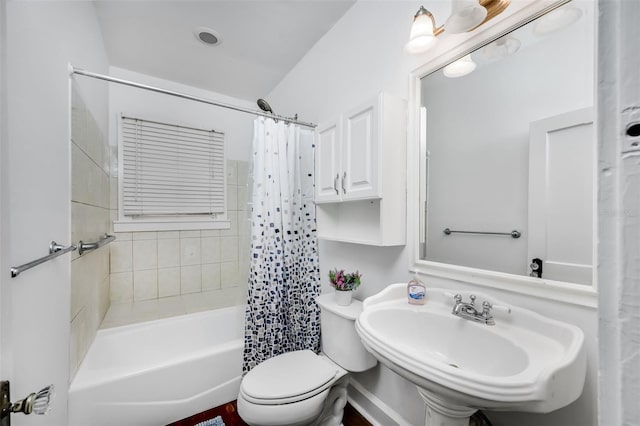 full bathroom featuring sink, shower / tub combo with curtain, and toilet