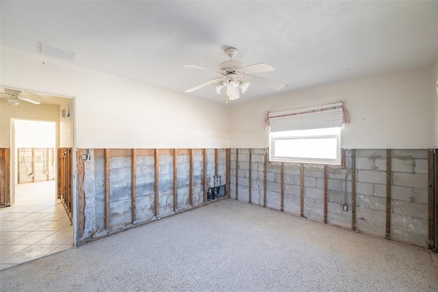 tiled spare room featuring ceiling fan