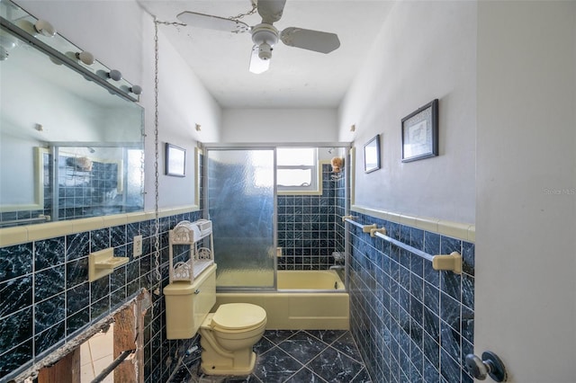 bathroom with toilet, bath / shower combo with glass door, and tile walls