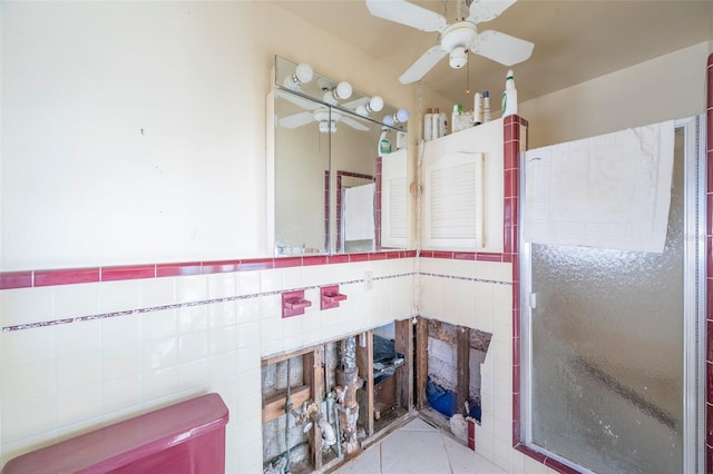 bathroom featuring tile patterned floors, tile walls, a shower with shower door, and ceiling fan