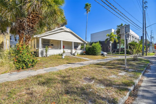 bungalow-style home with covered porch and a front yard