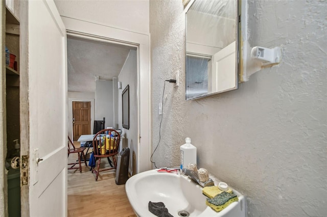 bathroom featuring sink, wood-type flooring, and a textured ceiling