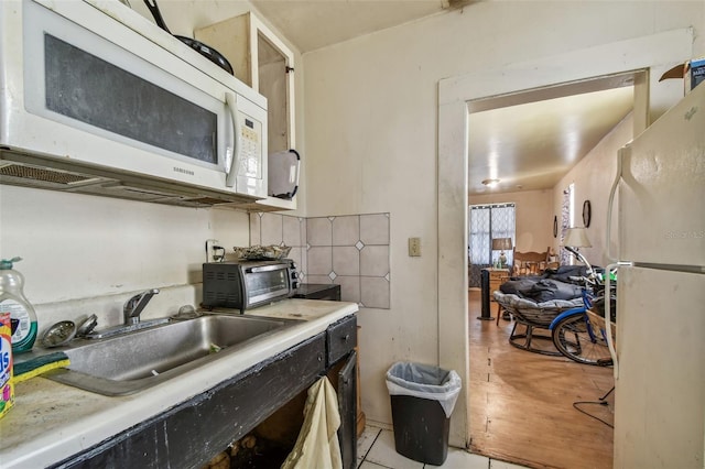 kitchen featuring sink, white appliances, and light hardwood / wood-style flooring