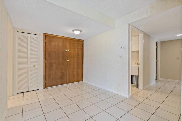 tiled entryway with a textured ceiling