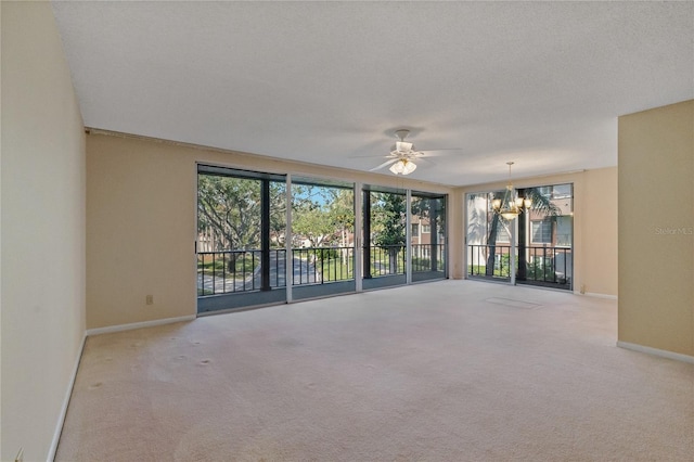 spare room with ceiling fan with notable chandelier, light colored carpet, and a textured ceiling