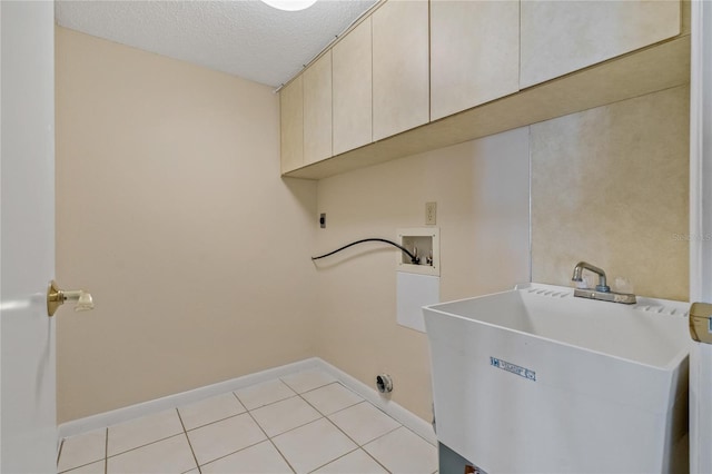 washroom with cabinets, hookup for a washing machine, a textured ceiling, electric dryer hookup, and sink