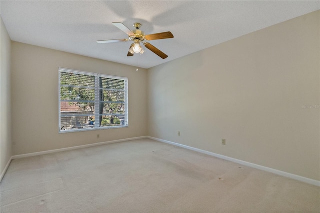 spare room featuring light carpet, a textured ceiling, and ceiling fan