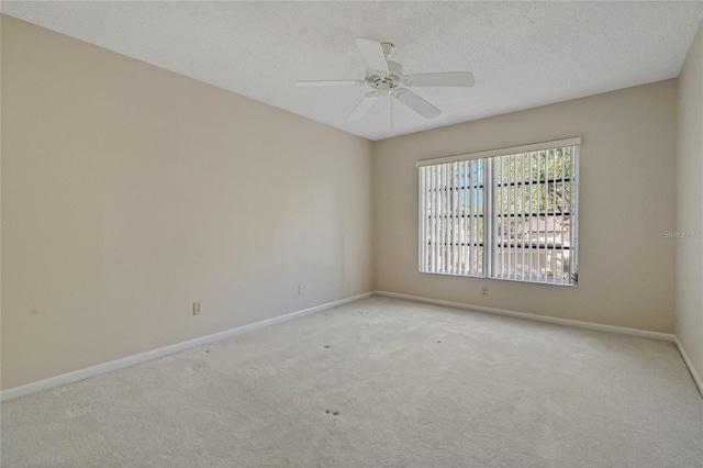 empty room with light carpet, ceiling fan, and a textured ceiling