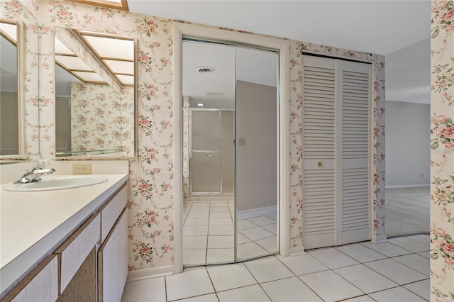 bathroom with tile patterned floors, vanity, and an enclosed shower