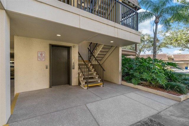 doorway to property featuring a patio area and elevator