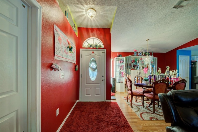 foyer entrance featuring light wood-type flooring and a textured ceiling