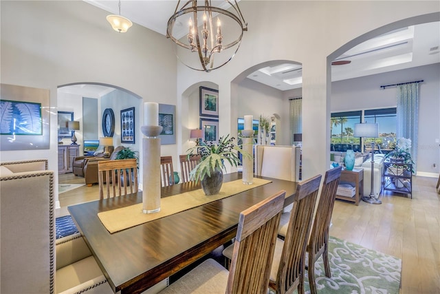 dining room featuring coffered ceiling, light hardwood / wood-style flooring, and an inviting chandelier