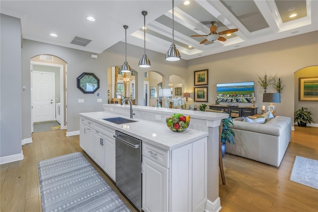 kitchen featuring white cabinetry, sink, stainless steel dishwasher, pendant lighting, and a kitchen island