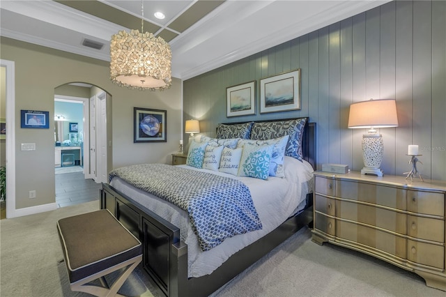 carpeted bedroom with crown molding and ensuite bath