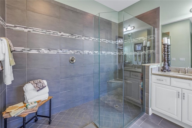 bathroom featuring a tile shower, vanity, and tile patterned floors