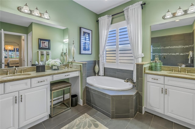 bathroom with tile patterned flooring, vanity, and a relaxing tiled tub