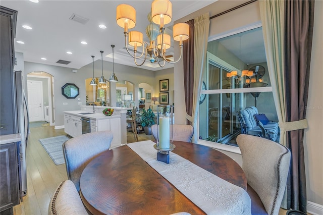 dining area with a chandelier, light hardwood / wood-style flooring, and sink