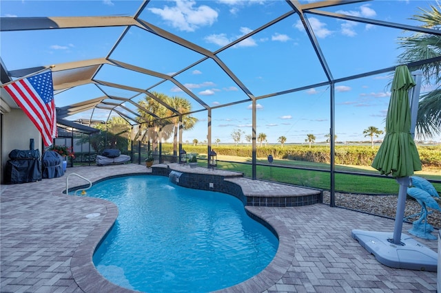 view of pool featuring a patio area, a yard, and glass enclosure