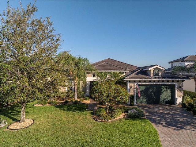 mediterranean / spanish home featuring a garage and a front lawn