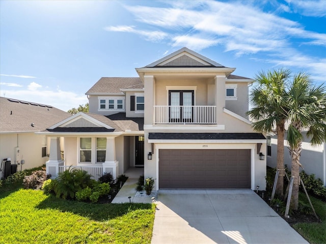 10551 Tranquil Meadow Loop, Riverview, FL 33569 - view of front of home featuring stucco siding, a balcony, a garage, driveway, and french doors