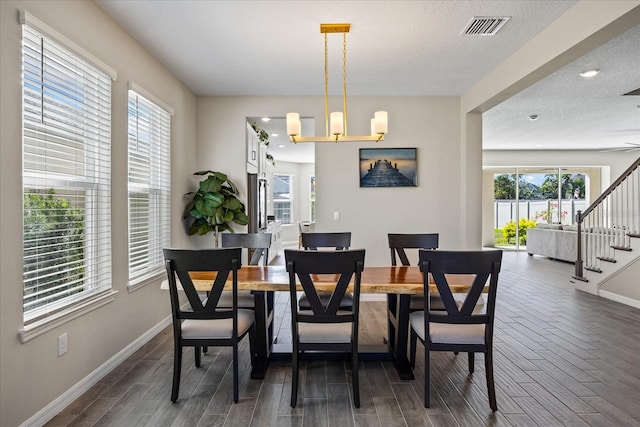 dining area featuring dark hardwood / wood-style flooring, a chandelier, and a textured ceiling