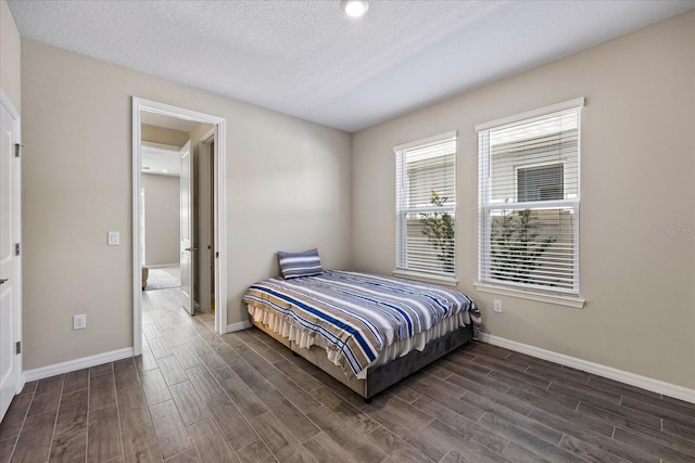 bedroom with a textured ceiling and dark wood-type flooring