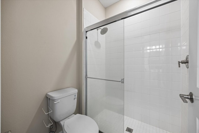 bathroom with toilet and a shower with shower door