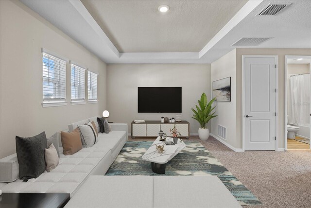 living room featuring carpet and a textured ceiling