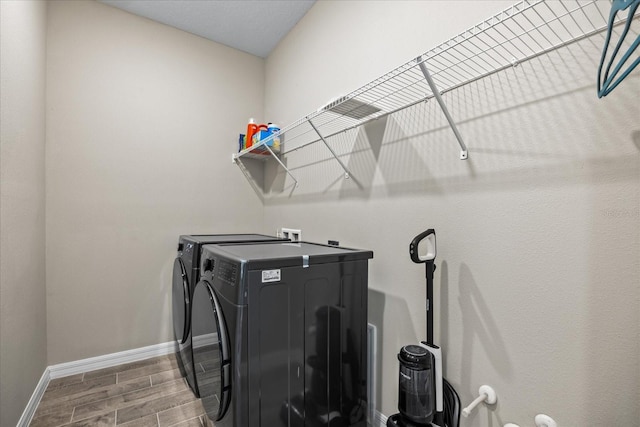 laundry area with hardwood / wood-style floors and washing machine and clothes dryer