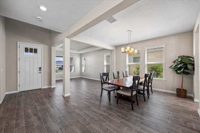 dining space with dark hardwood / wood-style flooring, a textured ceiling, and a notable chandelier