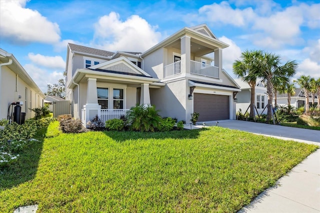 view of front of property with covered porch, a garage, a balcony, and a front yard