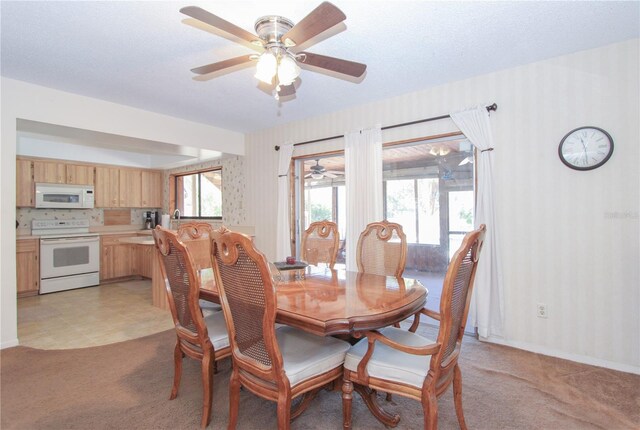 dining space featuring light carpet and a textured ceiling