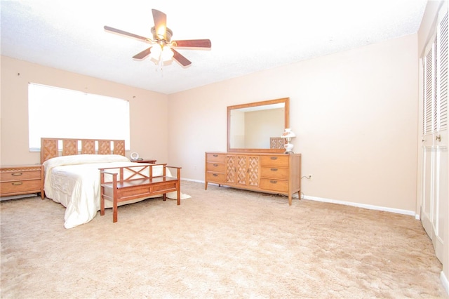 bedroom featuring ceiling fan, light colored carpet, a textured ceiling, and a closet