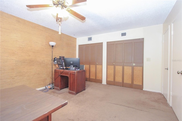 office space with carpet, a textured ceiling, and ceiling fan